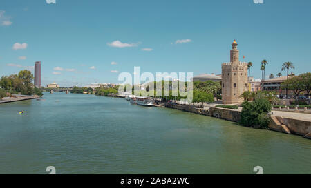 Views of the city from the bridge Puente San Telmo over Guadalquivir river towards watchtower Torre del Oro, Triana bridge and neighborhood, Seville Stock Photo