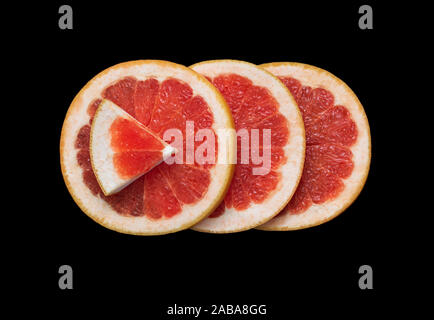 Juicy sliced grapefruit isolated on black background closeup. Flat lay. Bright red grapefruit citrus fruit cut in half. Macro, top view. Minimalistic Stock Photo