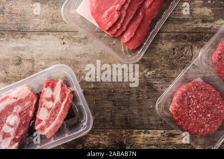 Different types of meat packaged in plastic on wooden table. Top view Stock Photo