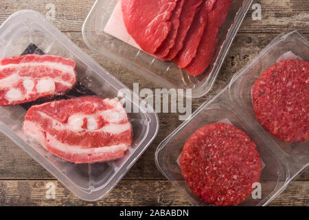 Different types of meat packaged in plastic on wooden table. Top view Stock Photo