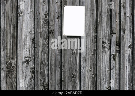 small white piece of paper with tacks pinned on old wood wall Stock Photo