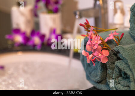 pink flower on green towel in bathroom Stock Photo