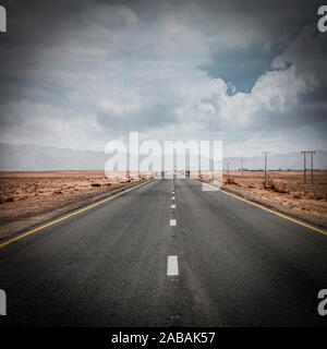 lonely road in the middle of the wadi rum desert in Jordan. no one around. Concept of adventure and freedom. Stock Photo
