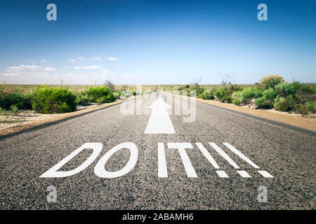 Eine unendlich lange Strasse mit der wegweisenden Aufschrift: 'Do It!' Stock Photo