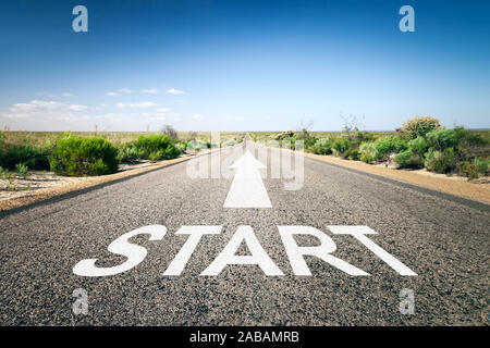 Eine unendlich lange Strasse mit der wegweisenden Aufschrift: 'Start' Stock Photo