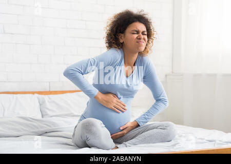 Labor contractions. Pregnant woman having pain in belly Stock Photo