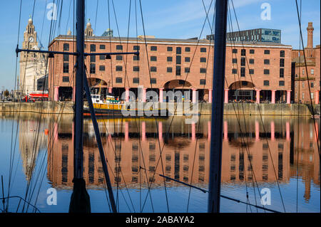 The Albert Dock in Liverpool shot through the rigging of a boat moored at the side. The Liver Building is just visible. Stock Photo