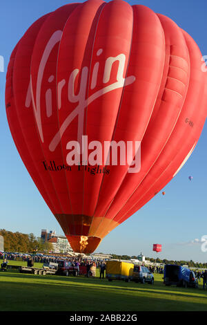 Red and white Virgin hot air balloon ready for take off  at York Balloon Fiesta, North Yorkshire, England, UK. Stock Photo