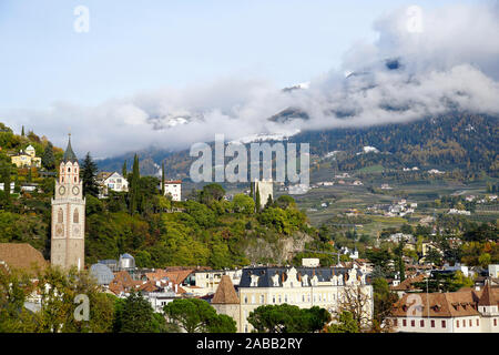City of Merano and St. Nicolaus church in Merano in South Tirol, Italy. Cloudy autumn day. Stock Photo