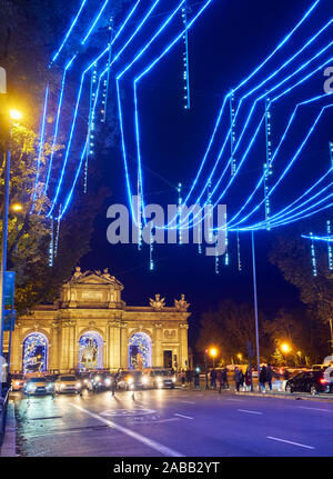 Alcala street illuminated by christmas lights at nightfall with the Alcala Gate (Puerta de Alcala) in the background. Madrid, Spain. Stock Photo