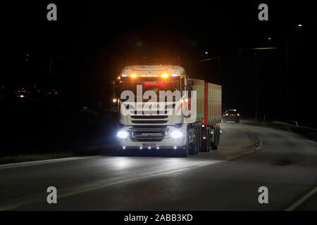 Scania R730 truck of Transport Stromberg in seasonal sugar beet transport lights up the dark road with bright headlights. Salo, Finland. Nov 22, 2019. Stock Photo