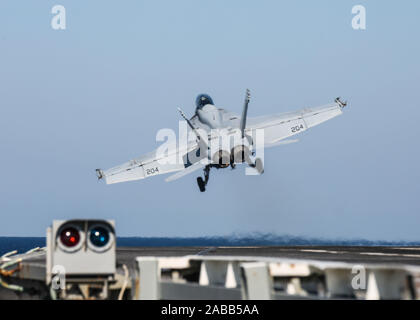 A U.S. Navy F/A-18F Super Hornet fighter attached to the Jolly Rogers of Strike Fighter Squadron 103 launches from the flight deck of the aircraft carrier USS Abraham Lincoln during operations November 22, 2019 in the Arabian Sea. Stock Photo