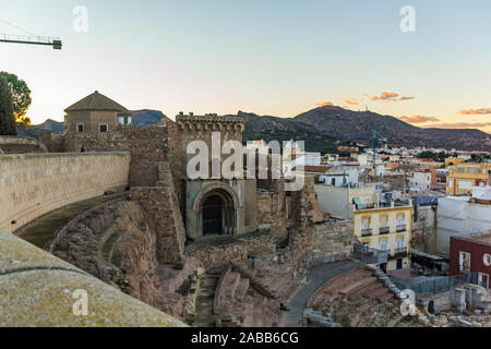 Aerial panoramic view of port city Cartagena in Spain with famous roman amphitheater. Beautiful sunset over the mountains. Wide angle lens panorama. Stock Photo