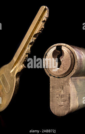 A old door lock on a dark background. A patent and keys to secure the front door. A black background. Stock Photo