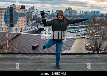 Young happy hipster man with drone in hands on the roof. Stock Photo