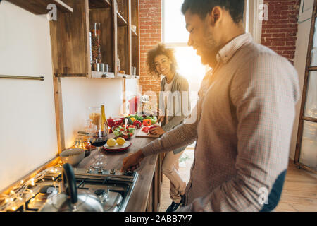 Happy african-american couple cooking dinner in kitchen Stock Photo