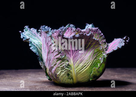 Red cabbage isolated on black background. Red and green headed cabbage, calciferous vegetables Stock Photo