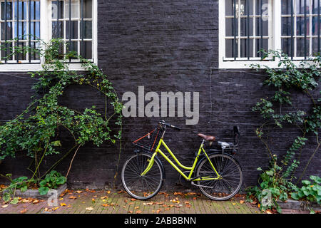 Traditional dutch bicycle parked on near brick wall in Amsterdam Stock Photo