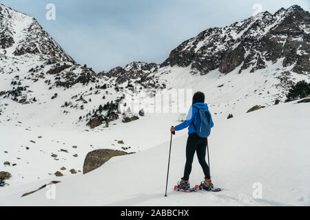 Young woman walking with snow rackets in high mountain Stock Photo