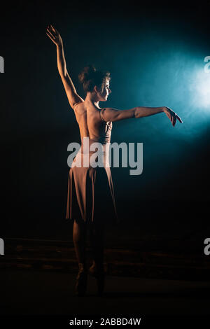 Ballerina is practicing moves on stage.Girl dancing, spinning around and smiling Stock Photo