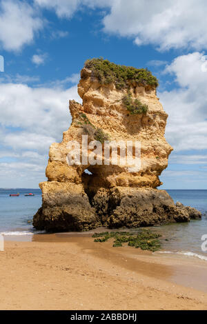 A rock formation and boats along the Praia da Dona Ana beach in Lagos, Portugal Stock Photo