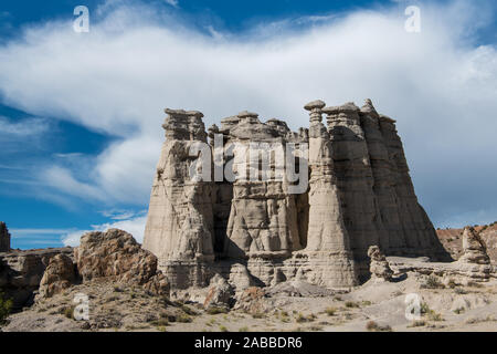 A steep white sandstone rock formation under a large storm cloud and blue sky in Plaza Blanca near Abiquiu, New Mexico, USA Stock Photo