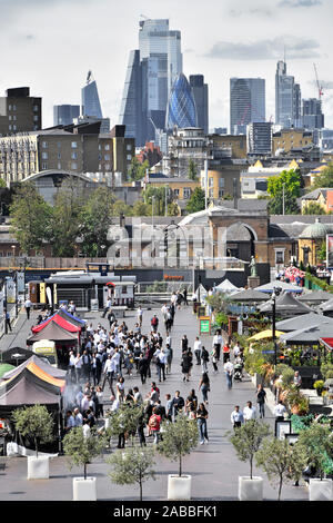 Canary Wharf aerial view busy outdoor street food business stalls at West India Quay City of London cityscape skyline beyond East London Docklands UK Stock Photo