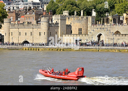 Passengers & crew on Thames Rockets high speed sightseeing tour boat passes famous historical Tower of London Royal Palace & Fortress Tower Hamlets UK Stock Photo