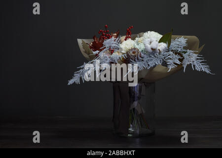 Christmas and New Year composition bouquet in a glass vase on a dark background, selective focus Stock Photo