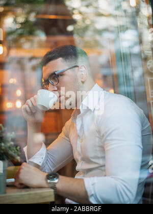 Intelligent young man drinking coffee Stock Photo