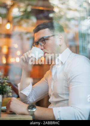 Intelligent young man drinking coffee Stock Photo