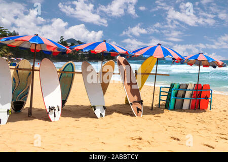 Surfboards and bodyboards under umbrellas on Surin Beach, Phuket, Thailand Stock Photo