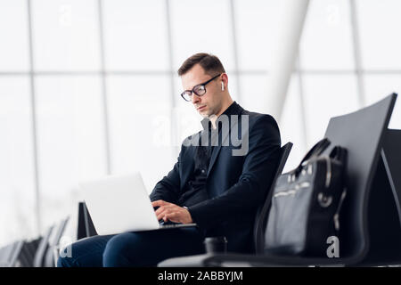 Working on laptop in airport while waiting for flight Stock Photo