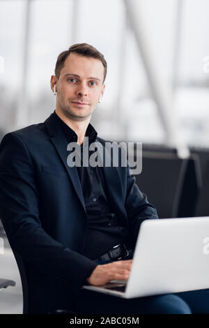 Working on laptop in airport while waiting for flight Stock Photo