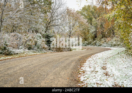 Windy gravel road through forest, fall scenery with a fresh snow - Honey Creek Conservation Area in western Missouri Stock Photo
