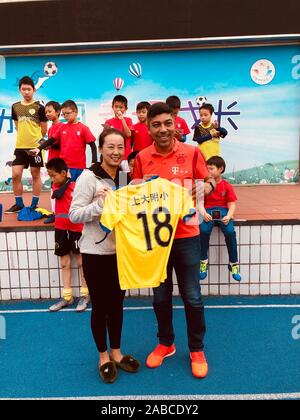 Retired Brazilian footballer Giovane Elber who played as a striker for Bayern Munich, right, takes photos with a teacher at Primary School Affiliated Stock Photo