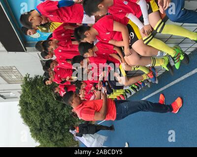 Retired Brazilian footballer Giovane Elber who played as a striker for Bayern Munich, left, interacts with students at Primary School Affiliated to Sh Stock Photo