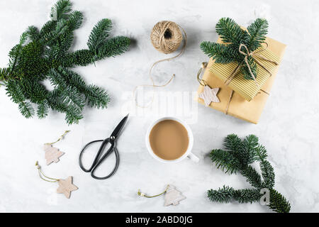 Christmas composition with hristmas gifts, fir tree branches, cup of coffee, festive decoration on white light background. Flat lay, top view Stock Photo