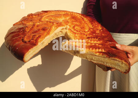 Woman's Hand Holding Cut Armenian Traditional Bread Called Gata, Showing Its Sweet Filling with Walnuts Stock Photo
