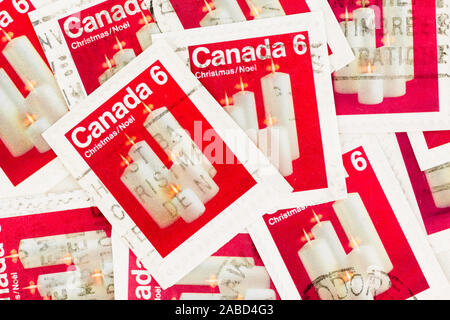 SEATTLE WASHINGTON -November 22, 2019: Christmas stamps of Canada on paper, featuring white candles on red background. Stock Photo