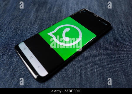 Odessa, Ukraine - October 26, 2019: WhatsApp app. WhatsApp logo visible on smartphone screen. Denim background. Soft focus Stock Photo