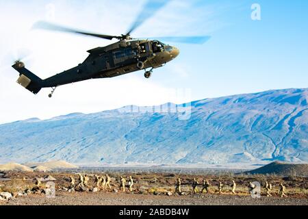 A UH-60 Blackhawk helicopter with 25th Combat Aviation Brigade drops off Soldiers from 1st Battalion, 27th Infantry Regiment “Wolfhounds”, 2nd Infantry Brigade Combat Team, 25th Infantry Division during a fire support coordination exercise Nov. 18, 2019 at Pohakuloa Training Area on the Island of Hawaii. The FSCX is one of the most realistic training events offered, allowing junior leaders to gain practical experience with calling coordinated fire missions and observing fires effects when paired with a maneuver element. Stock Photo