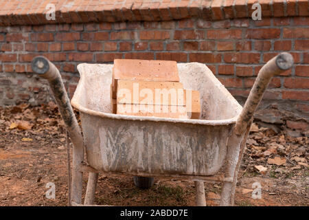 Close up picture of construction site. Bricks in a wheelbarrow Stock Photo