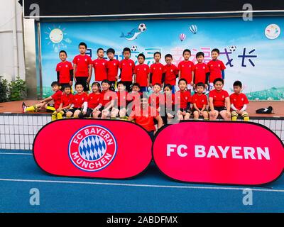 Retired Brazilian footballer Giovane Elber who played as a striker for Bayern Munich, middle, takes photos with students at Primary School Affiliated Stock Photo