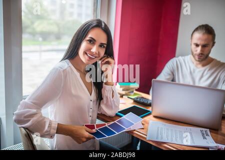 Beautiful interior designer smiling while working with husband Stock Photo