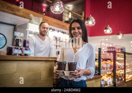 Businesswoman feeling cheerful standing in coffee shop in the morning Stock Photo