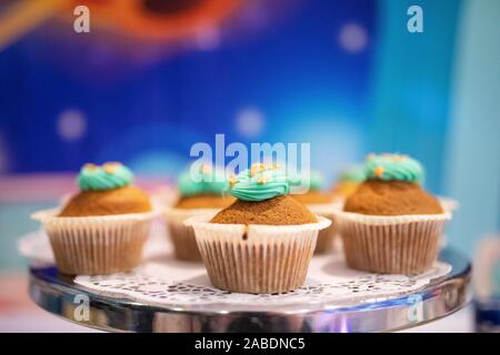 Delicious Christmas cupcakes on holiday table with cream with stars. Shallow depth of field Stock Photo