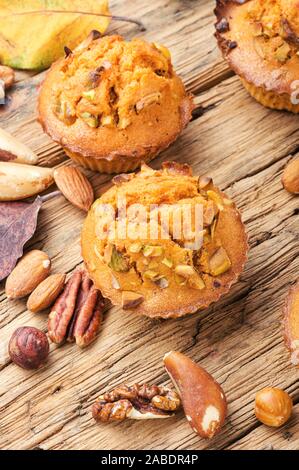 Sweet pumpkin muffins with nuts.Autumn food.Cupcake on old wooden table Stock Photo