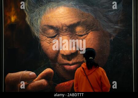 A visitor observes a piece of oil painting featuring a North Korean woman at the exhibition in Taiyuan city, north China's Shanxi province, 24 October Stock Photo