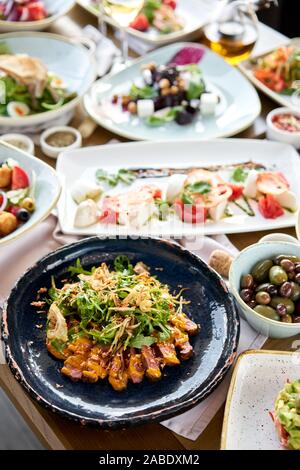 Roast beef, vegetables, carrot and oyster sauce. Sliced grilled beef barbecue Striploin steak and salad with arugula. Various snacks and antipasti on Stock Photo